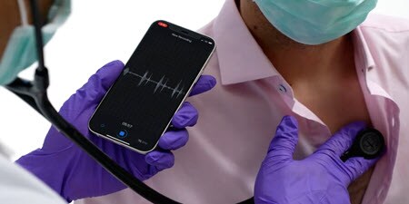 Lekár používajúci digitálny fonendoskop Littmann na pacientovej hrudi a vyhodnocujúci živé
