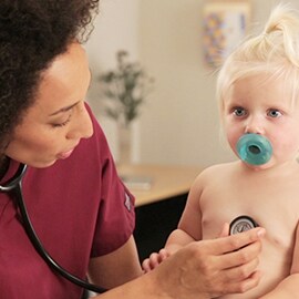 Pediatrická zdravotná sestra počúvajúca hrudník batoľaťa fonendoskopom 3M Littmann Classic III. 