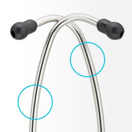 Ušné hadičky fonendoskopu 3M Littmann z lesklého hliníka, navzájom symetricky prekrížené, s čiernymi ušnými vložkami na koncoch. 