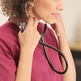 Zdravotná sestra, ktorá si nasadzuje fonendoskop 3M Littmann Classic III.