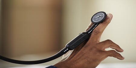 Detail Littmann CORE Digitálneho fonendoskopu v prstoch osoby.
